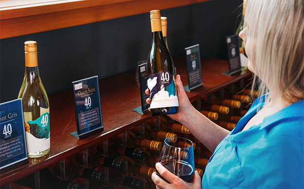Woman looking at bottles of 40 Knots wines