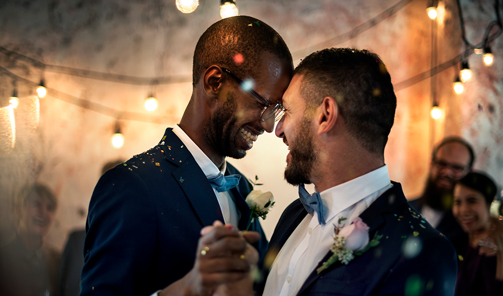 Image of gay couple dancing at wedding.